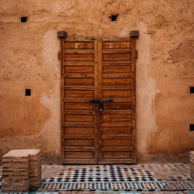 Old wooden doors with ornate tilework in courtyard
