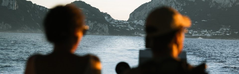 Two people watch islands across the water.