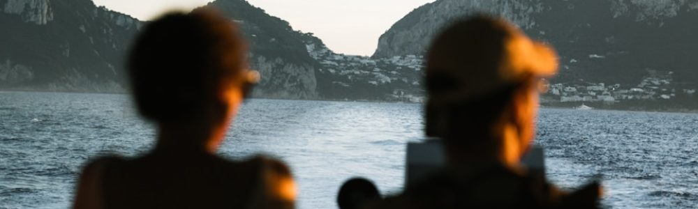 Two people watch islands across the water.